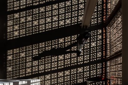 Photo of geometric patterned shadows on a floor created by lattice-like screens