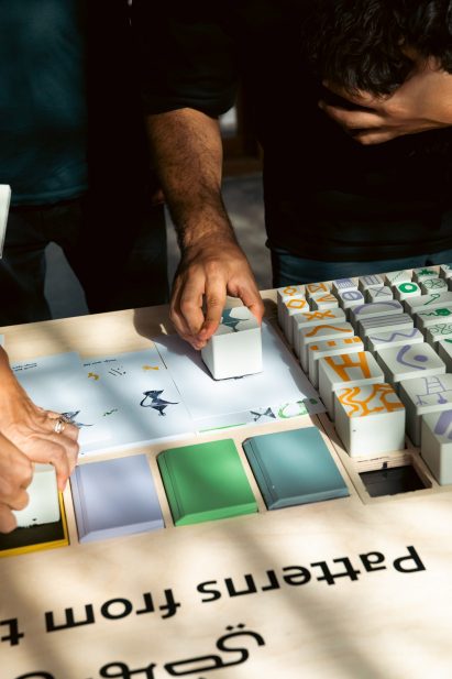 Close-up photo of people interacting with a museum exhibit on pattern and design