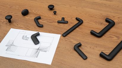 Photo of various loose door and window handles strewn across a desk