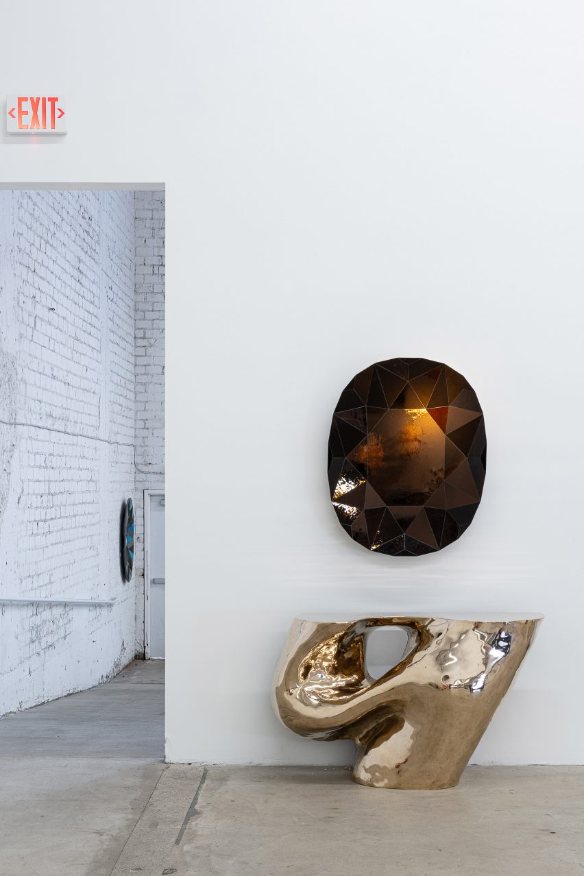 Gold sculpture placed underneath a wall hanging