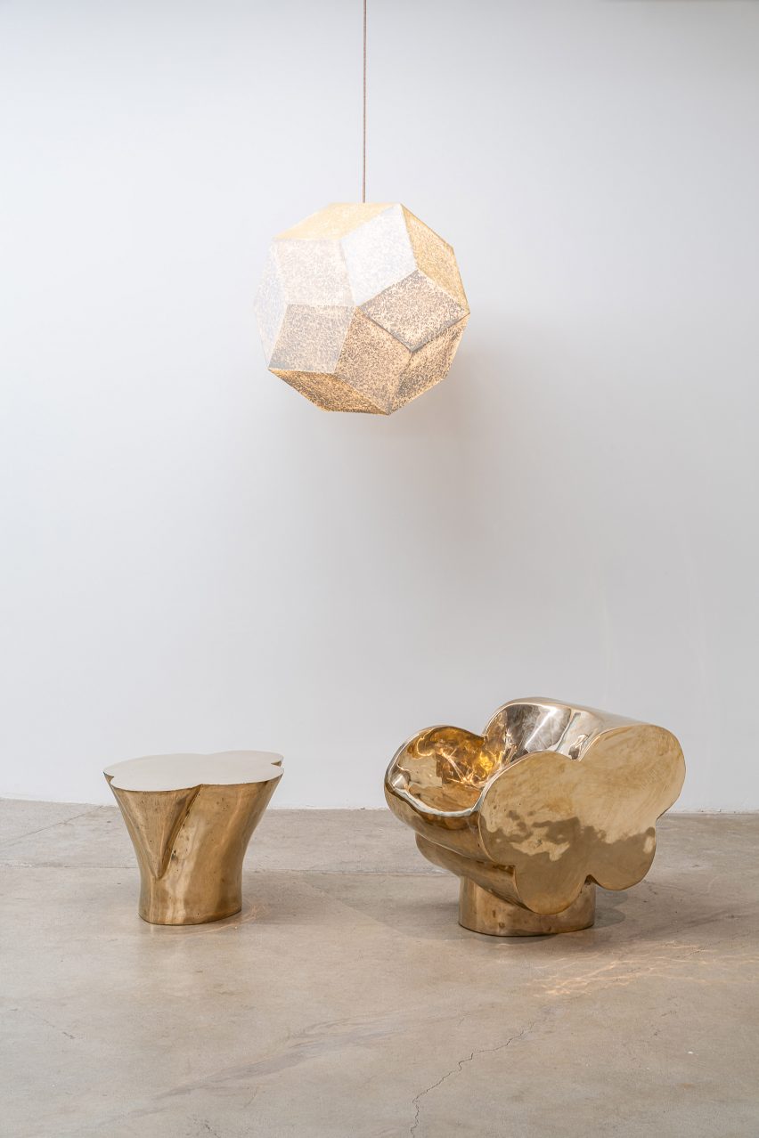 A couple of golden sculptures with hanging pendant above
