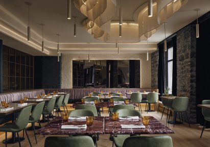 Dining room with marble topped tables, green chairs and cream walls