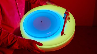 Hands holding up glowing Turntable II by Brian Eno for Paul Stolper Gallery