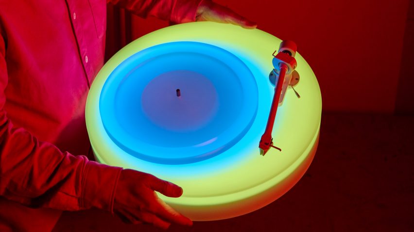 Hands holding up glowing Turntable II by Brian Eno for Paul Stolper Gallery