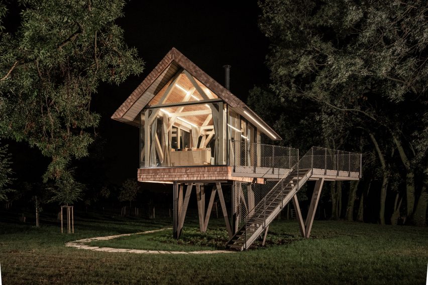 Exterior of glass micro house at night by Jan Tyrpekl in Austria