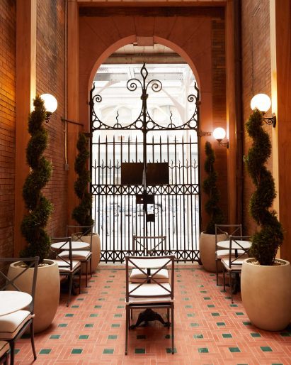 Cafe in a courtyard behind historic wrought iron gates