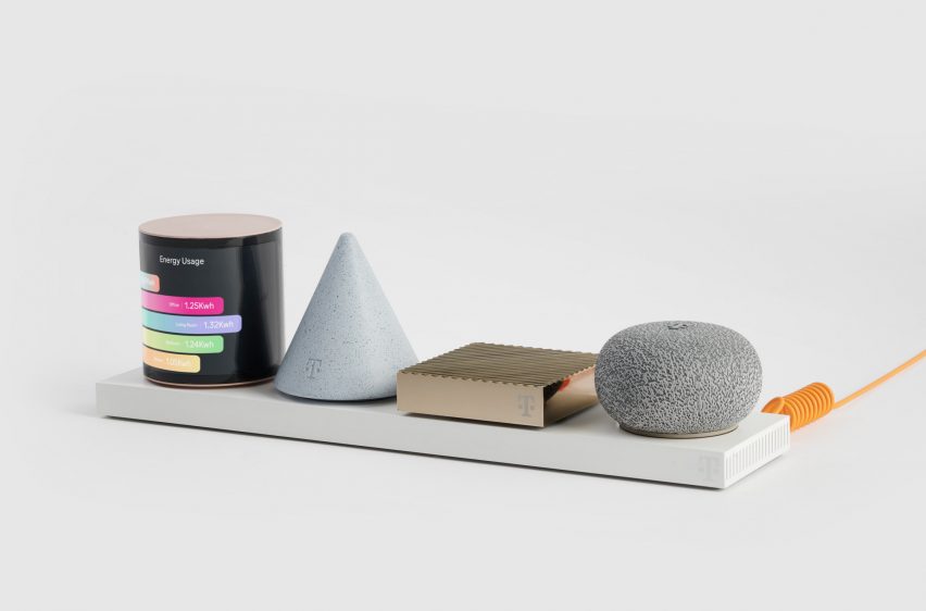 Photo of Layer's Concept Level prototype showing a cylindrical module wrapped in a screen displaying a colourful bar graph, an inverted cone-shaped light grey module, a slim gold bar module and a squashed ball-shaped module with a textured silver surface, all sat on a white base plate. The base is attached to a bright orange wire