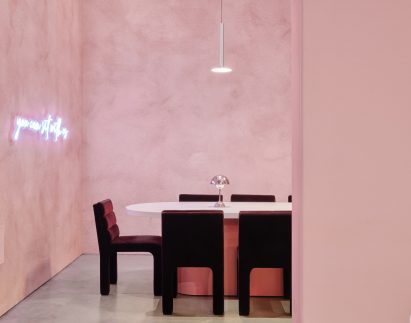 Velvet chairs underneath aluminum light fixture