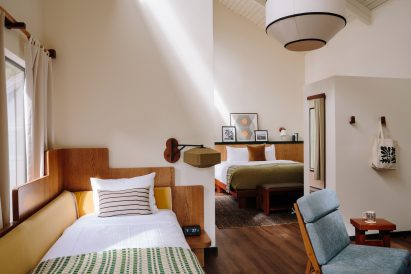 Bright guest suite with a double bed, day bed and blue lounge chair