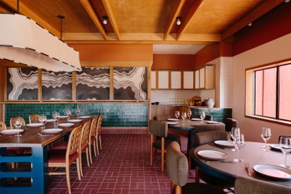 Dining room featuring brick flooring, blue-green tilework and eclectic contemporary furniture