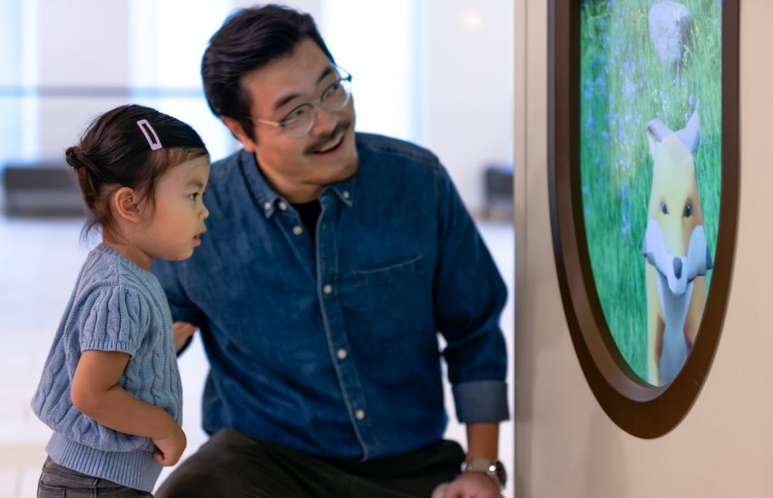 Parent and child smiling at screen