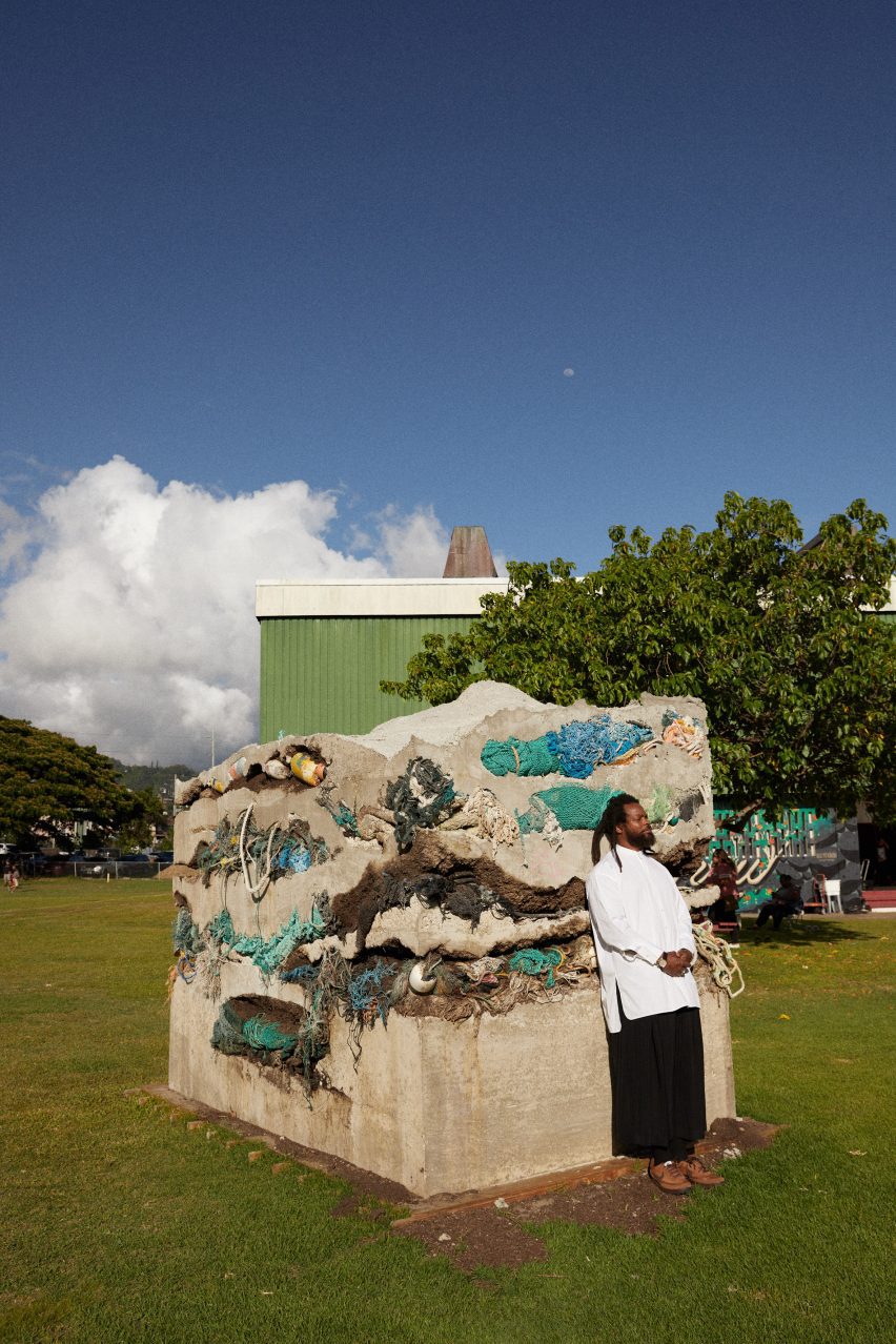 Michael Bennett leaning against a sculpture