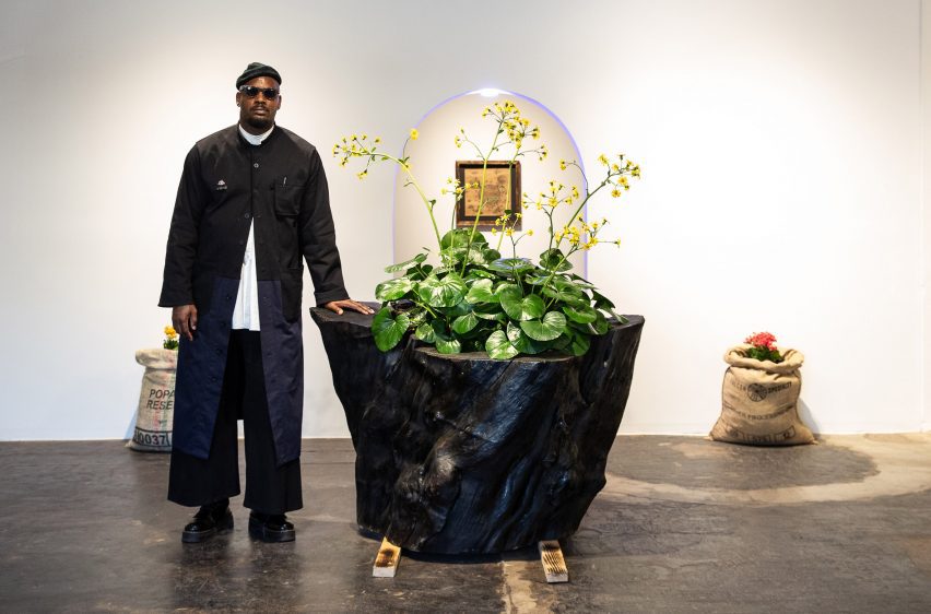 A man standing next to a large planter