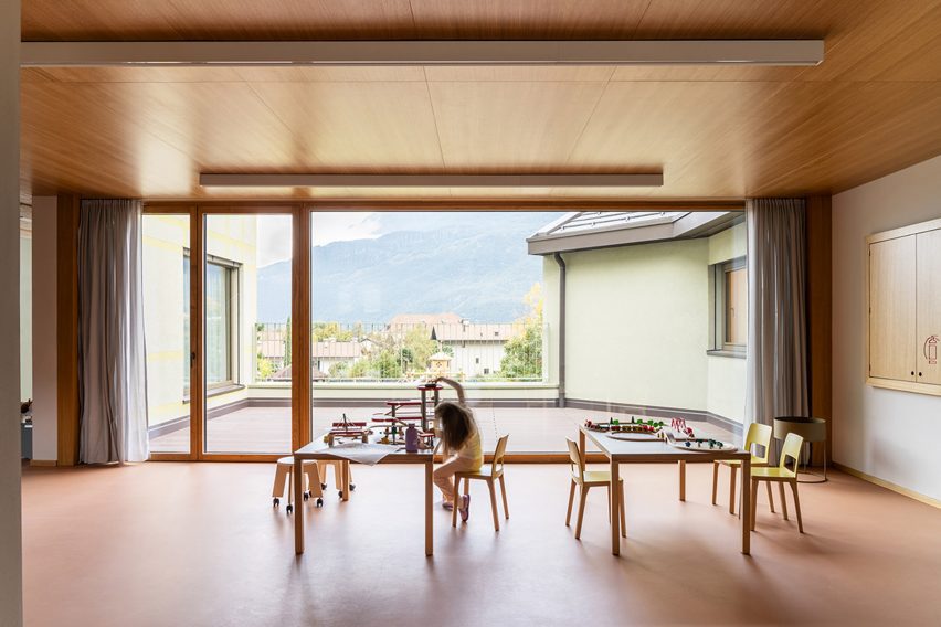 Kindergarten activity room with young girl playing at a table