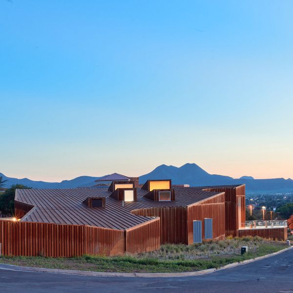 Corten steel museum at dusk with mountains in the background