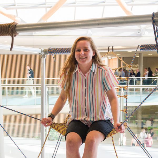 girl sitting on swing-like installation