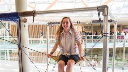 girl sitting on swing-like installation