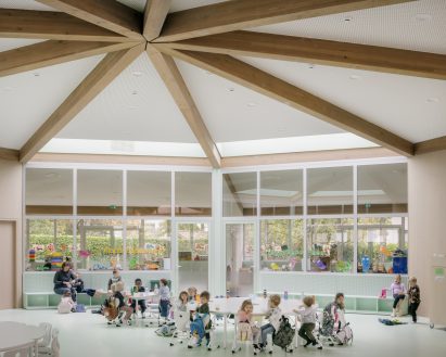 Hall in Belgian kindergarten with children eating