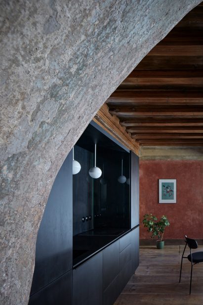 View of kitchenette in living room with dark wooden beams