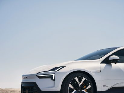 Image of the front of a white car with sleek headlights in the shape of two parallel blades