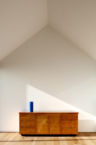 White gabled room with wooden console