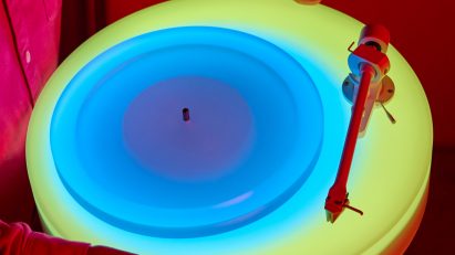 Hands holding up glowing Turntable II by Brian Eno for Paul Stolper Gallery