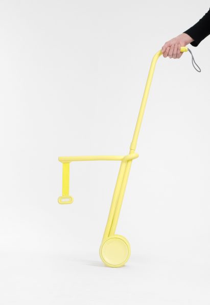 Person holding yellow walking aid for dogs