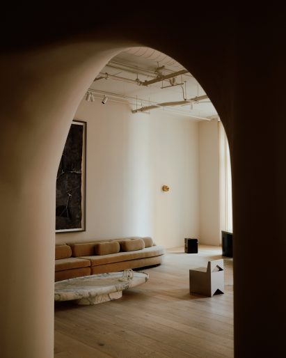 Double-height gallery space viewed through arched opening