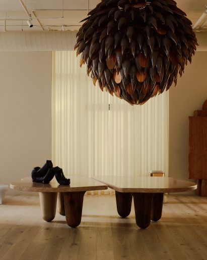 Giant bronze and glass chandelier above an organic-shaped dining table