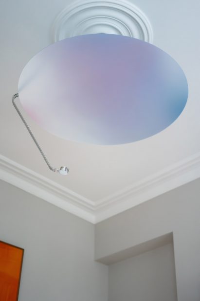 Photo of the Sunday Light reflector when the LED is off, showing a pearlescent, flat, circular panel
