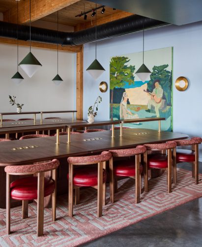 Rows of walnut worktables with red upholstered seating