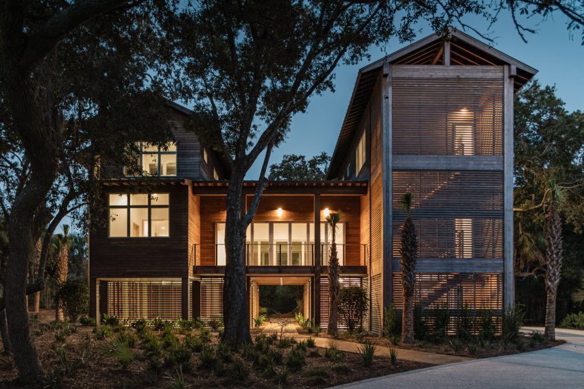 A wooden house lit up at night