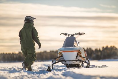 Man walking up to Alfa snowmobile by Vidde and Pininfarina