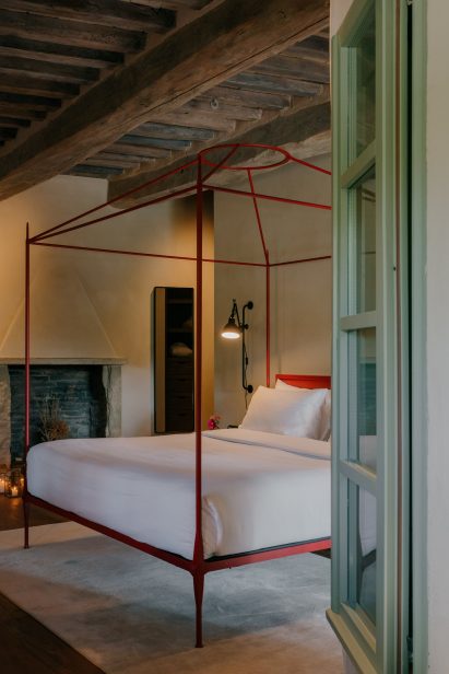 Bedroom with a red-framed, four-posted bed