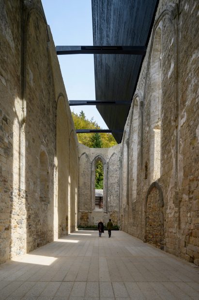 Blackened wood and steel roof over church in Žiče Charterhouse by Medprostor in Slovenia