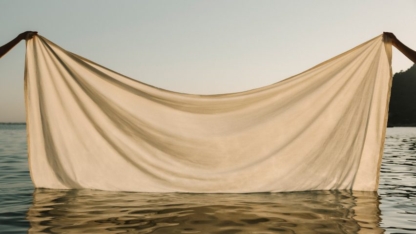 Photo of two hands lifting a sheet from the sea