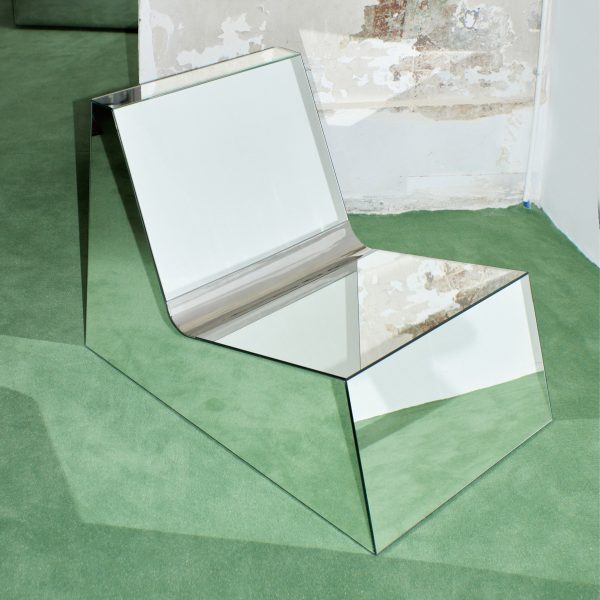 Photo of reflective chair on green floor