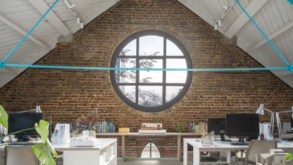 First floor workspace with rose window in Addison Studios by Tigg + Coll Architects