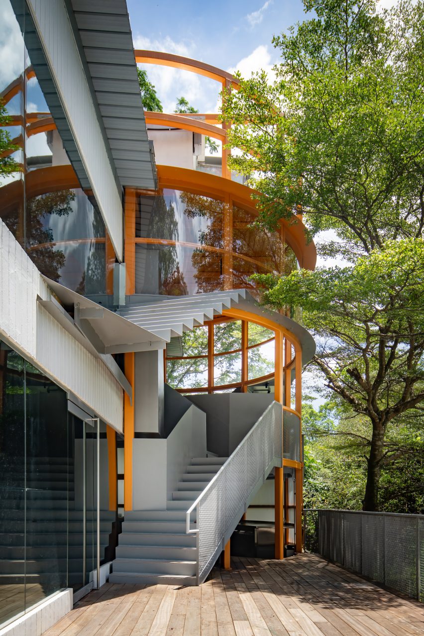 Cylindrical steel frame cutting into a modernist building