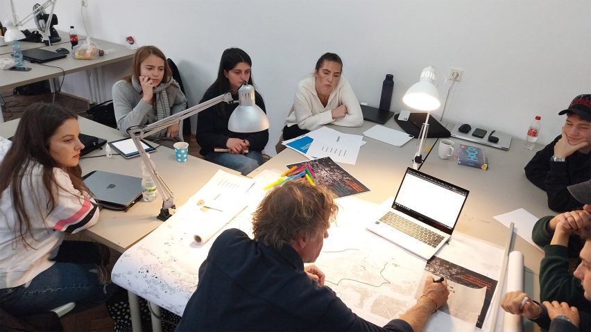 a photograph of students sat around a table working together