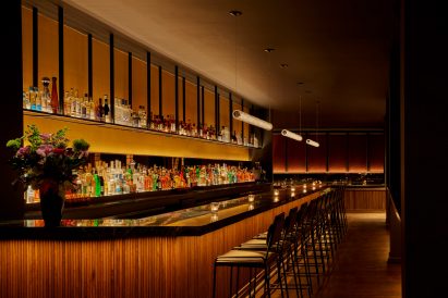 A long bar topped with black soapstone and fronted with tambour wood