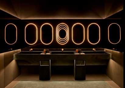 Hand-washing station with leathered soapstone basins and rings of light above
