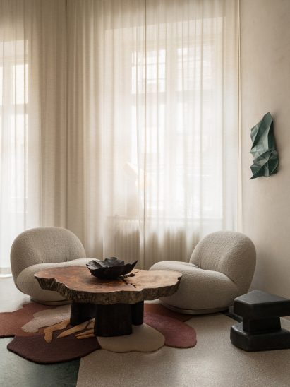 Soft white chairs in front of curtained window