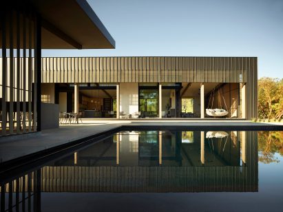 Standing seam rectilinear home overlooking a swimming pool