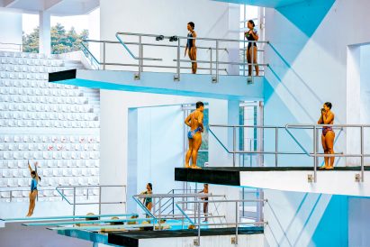 Swimmers poised on diving boards at the Aquatic Stadium Gelora Bung Karno, Jakarta