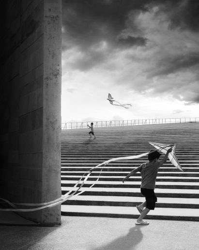 A striking photo of a boy flying a kite playing on the steps of the Teopanzolco Cultural Center in Mexico