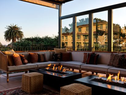 Covered terrace with cushioned seating around fire pits