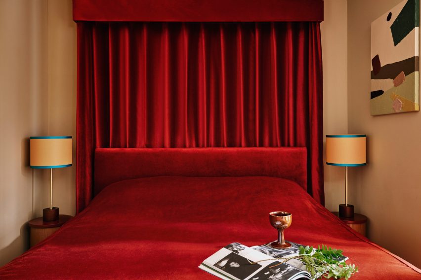Velvet red bedspread and drapes in Locke studio-style apartment