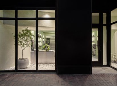 Storefront with greenery behind large windows