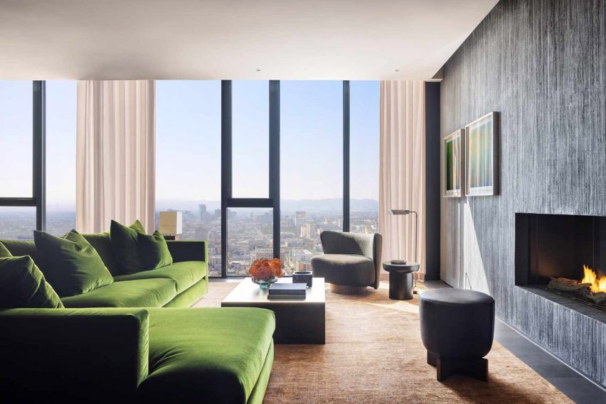 Green couch facing fireplace
